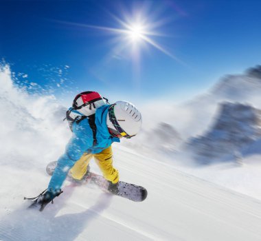 Yokuş aşağı hızlı hareket çalışan genç adam snowboarder