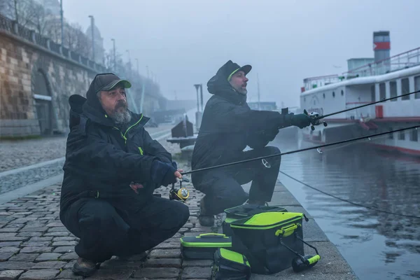 Dos pescadores tratando de pescar en el río, la pesca urbana . — Foto de Stock