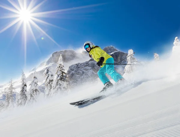 Ung kvinna skidåkare kör ner backen i alpina berg. — Stockfoto