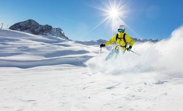 Joven esquiador corriendo cuesta abajo en el hermoso paisaje alpino . — Foto de Stock