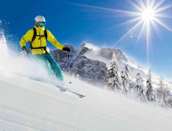 Skifahrer auf abschüssiger Piste in alpiner Landschaft. — Stockfoto