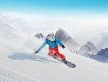 Yokuş aşağı Alpler'de çalışan genç adam snowboarder