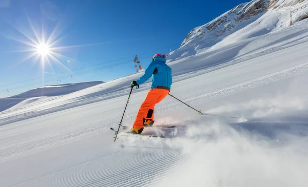 Jongeman afdaling skiën in de Alpen — Stockfoto