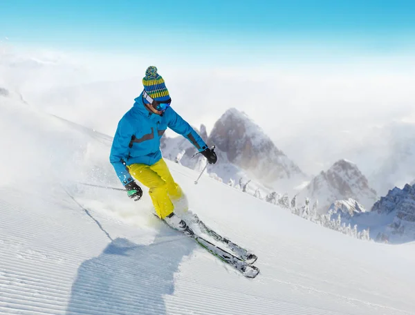 Jongeman afdaling skiën in de Alpen — Stockfoto