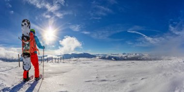 Kar ayakkabılarını toz karda yürürken snowboarder.