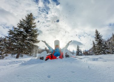 Toz karda oturup kar ayakkabıları ile snowboard.