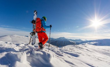 Kar ayakkabılarını toz karda yürürken snowboarder.