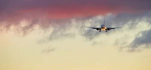 Commerciële vliegtuig straalvliegtuig landing in de zonsondergang — Stockfoto