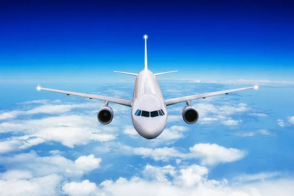 Commercial airplane jetliner flying above clouds in day light. — Stock Photo, Image