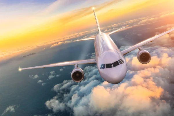 Літак реактивний літак літає над хмарами на красивому заході сонця — стокове фото