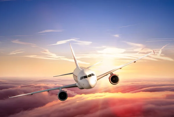 Flygplan linjejetplan flyger ovanför molnen i vacker solnedgång — Stockfoto