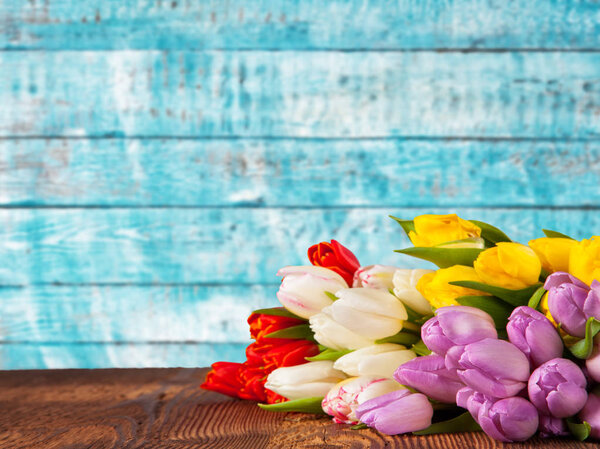 Bouquet of colored tulips placed on vintage wooden planks