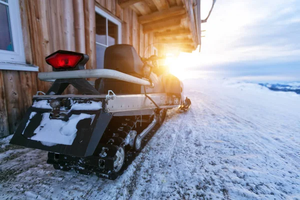 Closeup of snowmobile parking next to log cabin — Stock Photo, Image