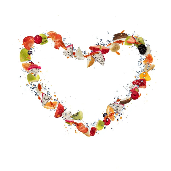 Pezzi di frutta fresca che volano a forma di cuore sul bianco — Foto Stock