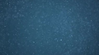 Mavi arka plan üzerinde gerçekçi parçacıkların ağır çekim