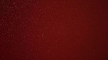 Kırmızı bir arka plan üzerinde gerçekçi parçacıkların ağır çekim