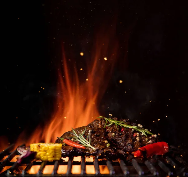 Rejilla de parrilla ardiente con trozo de carne de res y verduras a la parrilla . — Foto de Stock