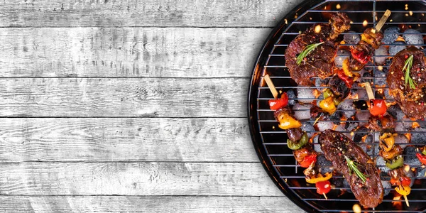 Blick von oben auf frisches Fleisch und Gemüse auf Grill auf Holz — Stockfoto