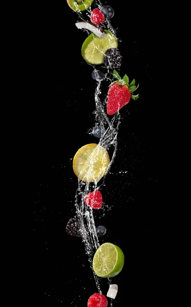 Stukjes fruit in water splash, geïsoleerd op zwarte achtergrond — Stockfoto