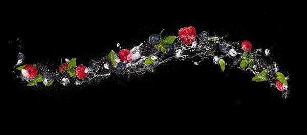 Mix ovoce berry ve stříkající vodě, izolovaný na černém pozadí — Stock fotografie