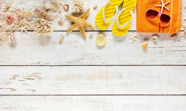 Accessori da spiaggia posizionati su tavole di legno bianco, vista dall'alto . — Foto Stock