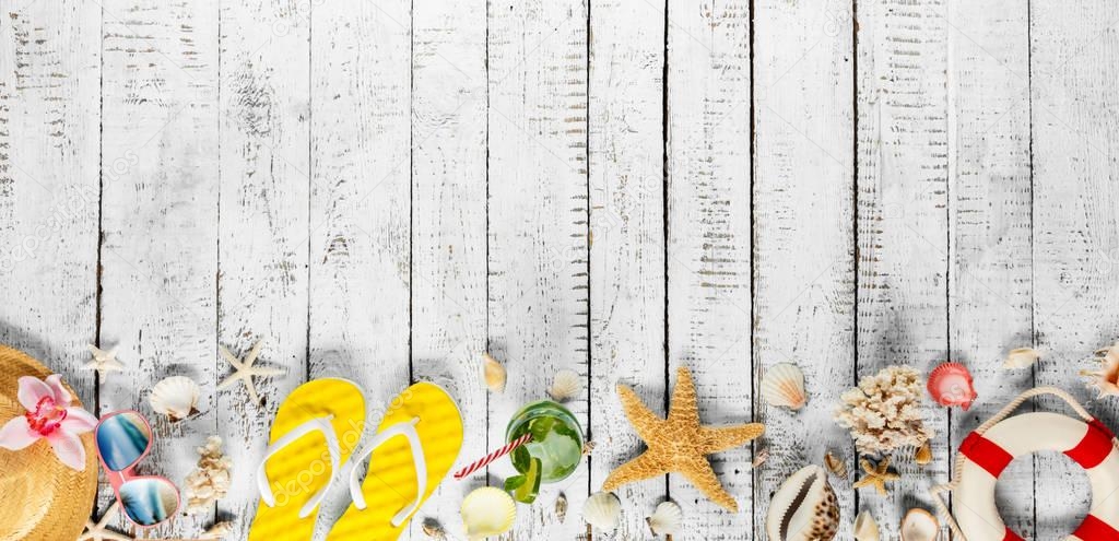 Beach accessories placed on white wooden planks, top view.