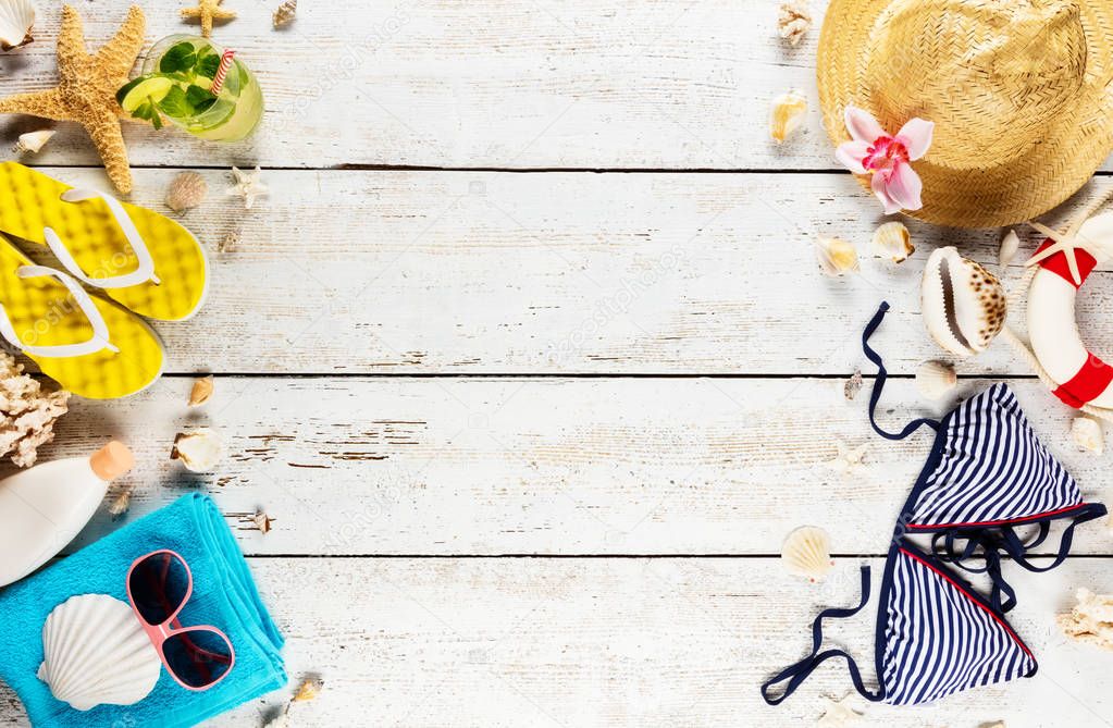 Beach accessories placed on white wooden planks, top view.