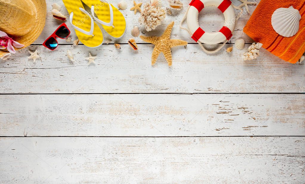 Beach accessories placed on white wooden planks, top view.