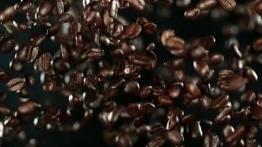 Uçan kahve çekirdekleri aşırı yavaş hareket ediyor. Yüksek hızlı sinema kamerası, 1000 fps..