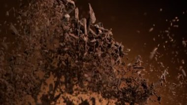 Çiğ çikolata talaşı uçan grup süper yavaş hareket ediyor. Yüksek hızlı sinema kamerası, 1000fps.