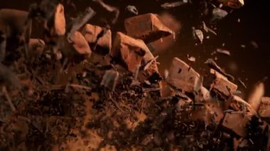 Çiğ çikolata parçalarından oluşan uçan bir grup süper yavaş çekim. Yüksek hızlı sinema kamerası, 1000fps.