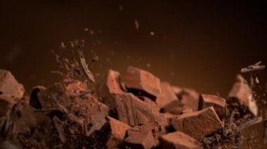 Çiğ çikolata parçalarından oluşan uçan bir grup süper yavaş çekim. Yüksek hızlı sinema kamerası, 1000fps.