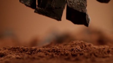 Düşen bir grup çiğ çikolata parçasının süper yavaş çekimi. Yüksek hızlı sinema kamerası, 1000fps.