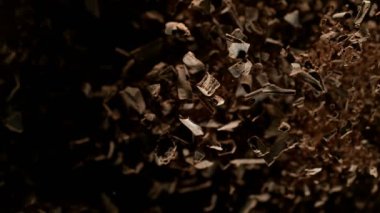 Çiğ çikolata parçalarından oluşan uçan bir grup süper yavaş çekim. Yüksek hızlı sinema kamerası, 1000fps.