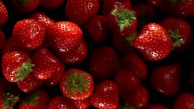 Siyah arka planda izole edilmiş çileklerin süper yavaş çekimleri. Yüksek hızlı sinema kamerası, 1000 fps..