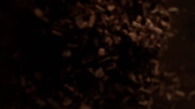 Çiğ çikolata parçalarından oluşan uçan bir grup süper yavaş çekim. Yüksek hızlı sinema kamerası, 1000fps.