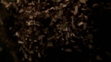 Çiğ çikolata parçalarından oluşan uçan bir grup süper yavaş çekim. Yüksek hızlı sinema kamerası, 1000fps.