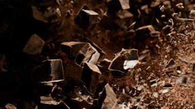 Freeze motion of flying group of raw chocolate pieces.