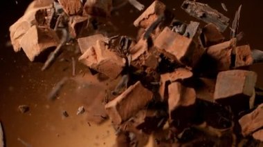 Süper yavaş çekimde, aşırı hız etkisiyle çiğ çikolata parçacıkları uçuyor. Yüksek hızlı sinema kamerası, 1000fps.