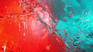 Neon ışıklarıyla aydınlatılmış su sıçratmanın süper yavaş çekimi. Çok hızlı bir kamerayla çekildi, 1000 fps..