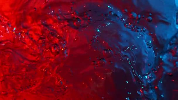 Mouvement super lent des éclaboussures d'eau éclairées par des néons. Filmé par caméra à très grande vitesse, 1000 images par seconde.