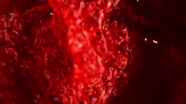 Mouvement super lent de verser du vin rouge, vue intérieure de la bouteille. Filmé sur caméra de cinéma à grande vitesse, 1000 images par seconde .