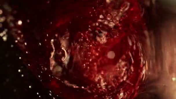Mouvement super lent de verser du vin rouge, vue intérieure de la bouteille. Filmé sur caméra de cinéma à grande vitesse, 1000 images par seconde .