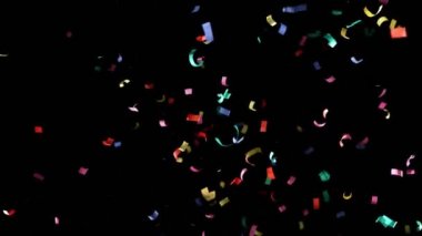 Siyah arka planda izole edilmiş uçan renkli konfetilerin süper yavaş çekimleri. Yüksek hızlı sinema kamerasıyla çekilmiş.