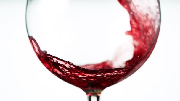 Super zpomalení nalití červeného vína v detailu, izolované na bílém pozadí. Natočeno na vysokorychlostní kameře, 1000 fps