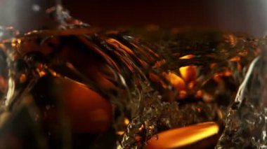 Süper makro çekimde buz küpünün viskiye dönüşmesi çok yavaş bir hareket. Yüksek hızlı sinema kamerası, 1000fps