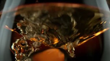 Süper makro çekimde buz küpünün viskiye dönüşmesi çok yavaş bir hareket. Yüksek hızlı sinema kamerası, 1000fps