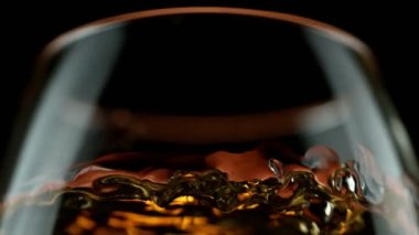 Viski, konyak ya da romun makroda sallanması çok yavaş bir hareket. Yüksek hızlı sinema kamerası, 1000 fps.