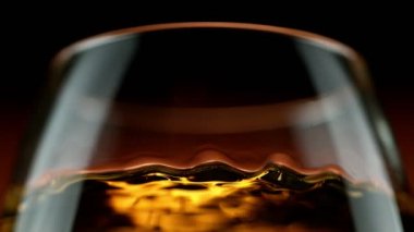 Viski, konyak ya da romun makroda sallanması çok yavaş bir hareket. Yüksek hızlı sinema kamerası, 1000 fps.