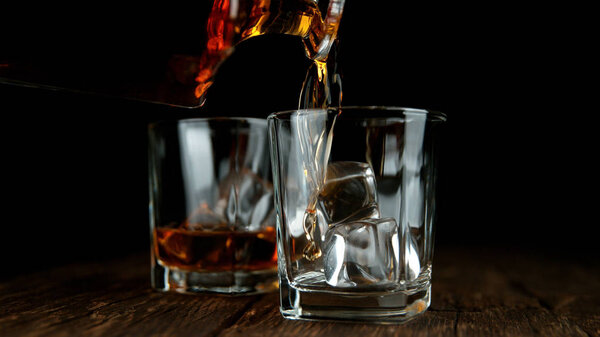 Деталь наливания виски в стакан
